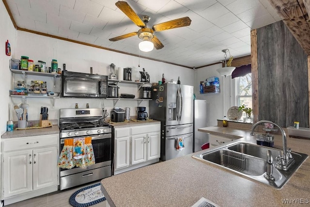 kitchen with crown molding, sink, ceiling fan, white cabinetry, and stainless steel appliances