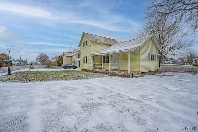 snow covered property with a porch