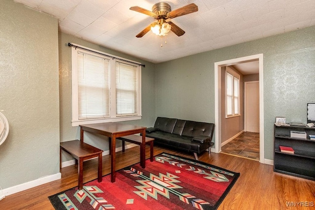 living area with hardwood / wood-style flooring and ceiling fan