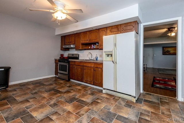 kitchen with white refrigerator with ice dispenser, sink, decorative backsplash, ceiling fan, and stainless steel range