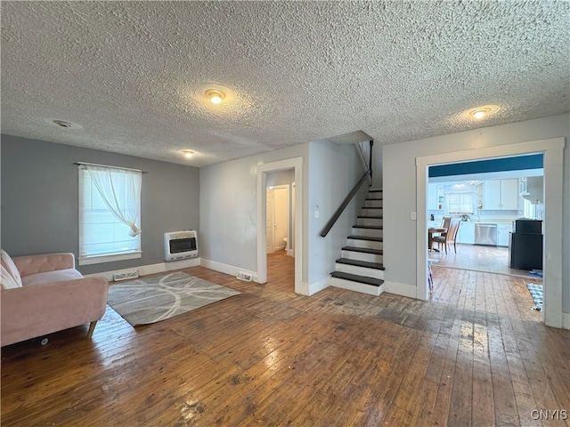 living room featuring heating unit, dark hardwood / wood-style flooring, and a textured ceiling