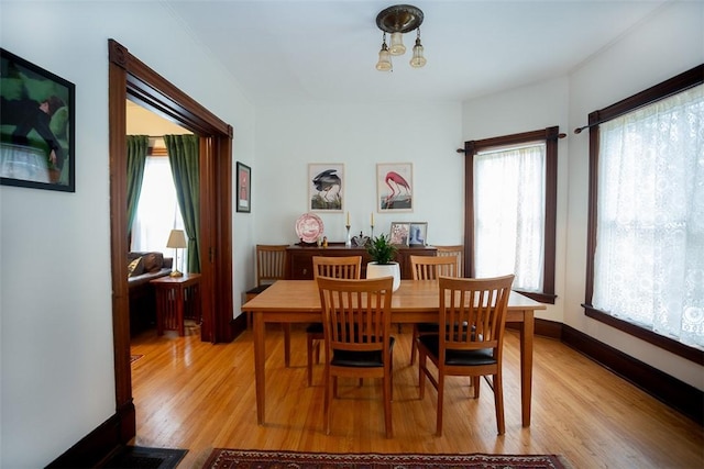 dining area featuring light hardwood / wood-style floors and an inviting chandelier