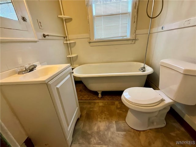 bathroom featuring vanity, toilet, and a bath