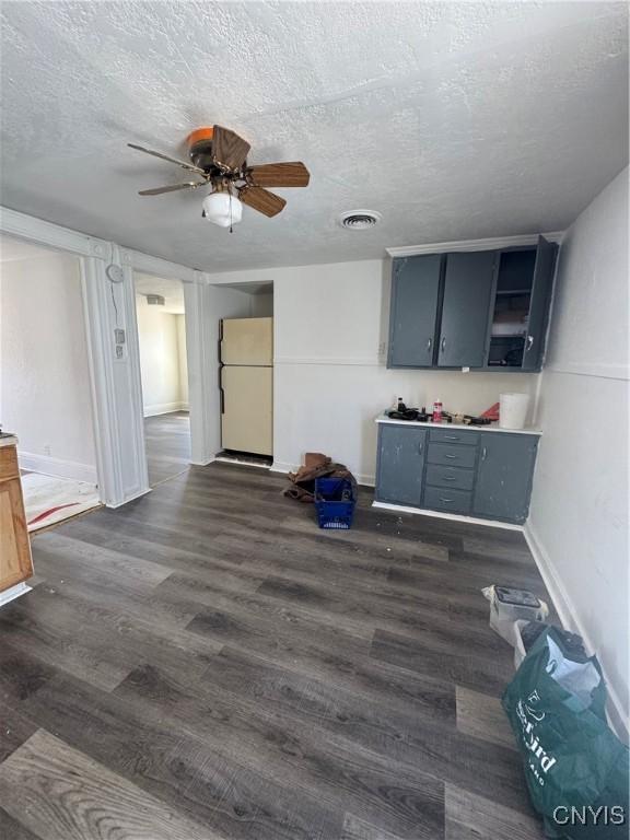744 Jay St, Utica, NY 13501 - unfurnished living room featuring a ceiling fan, a textured ceiling, dark wood finished floors, and baseboards