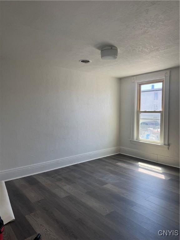 744 Jay St, Utica, NY 13501 - unfurnished room featuring dark wood-style flooring, baseboards, and a textured ceiling