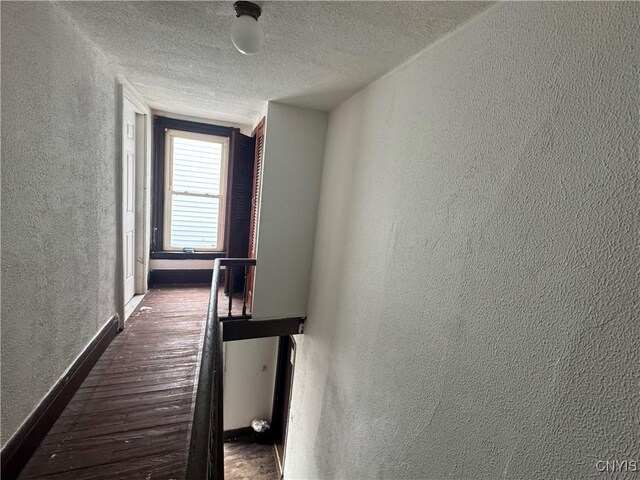 744 Jay St, Utica, NY 13501 - hall with a textured wall, a textured ceiling, baseboards, and wood finished floors
