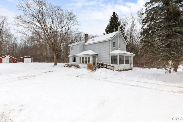 snow covered house with a storage shed