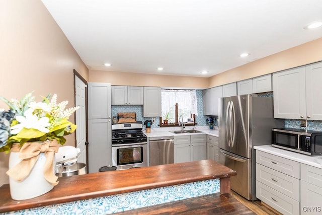 kitchen featuring backsplash, gray cabinetry, and appliances with stainless steel finishes