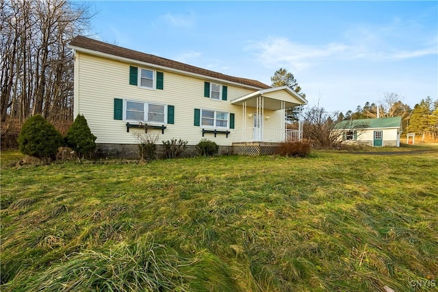 rear view of property featuring a lawn