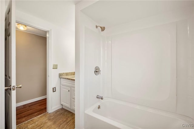 bathroom with hardwood / wood-style floors, vanity, and shower / bath combination