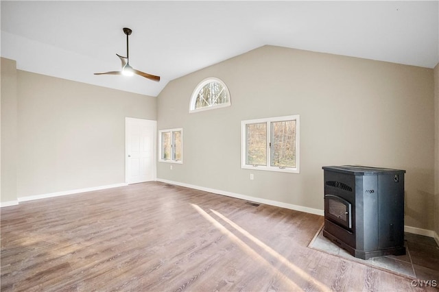 unfurnished living room featuring hardwood / wood-style floors, a wood stove, ceiling fan, and lofted ceiling