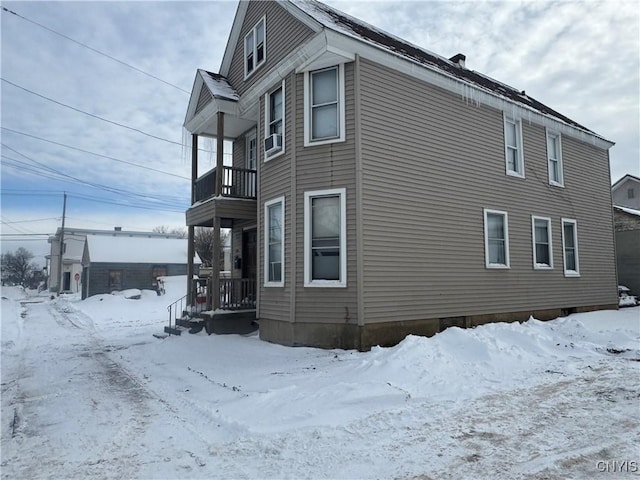 view of snow covered exterior with a balcony