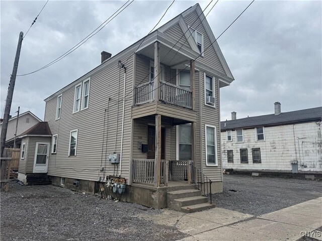 748 Jay St, Utica, NY 13501 - view of front of house featuring cooling unit, a porch, entry steps, a balcony, and a chimney