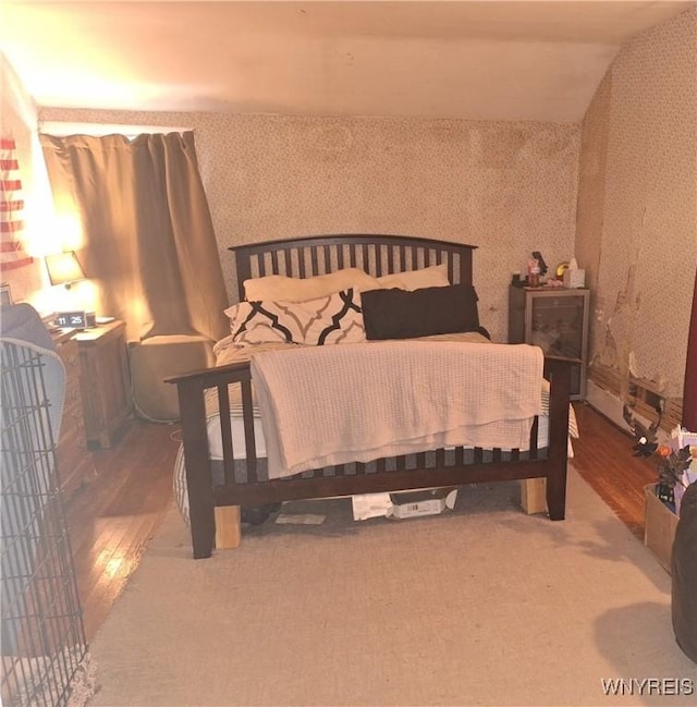 bedroom featuring hardwood / wood-style floors and lofted ceiling