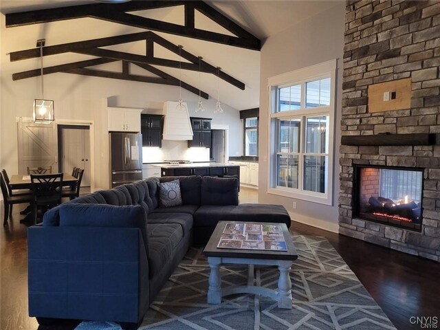 living room featuring a fireplace, beam ceiling, dark wood-type flooring, and high vaulted ceiling