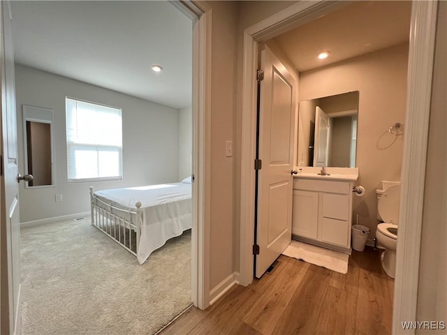 interior space featuring hardwood / wood-style flooring, vanity, and toilet