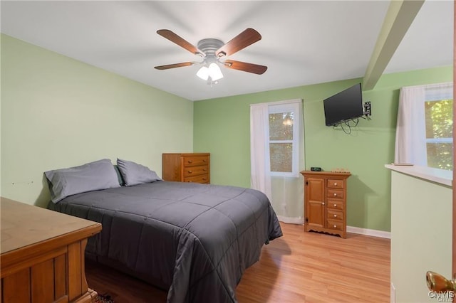 bedroom with beamed ceiling, ceiling fan, and light hardwood / wood-style floors