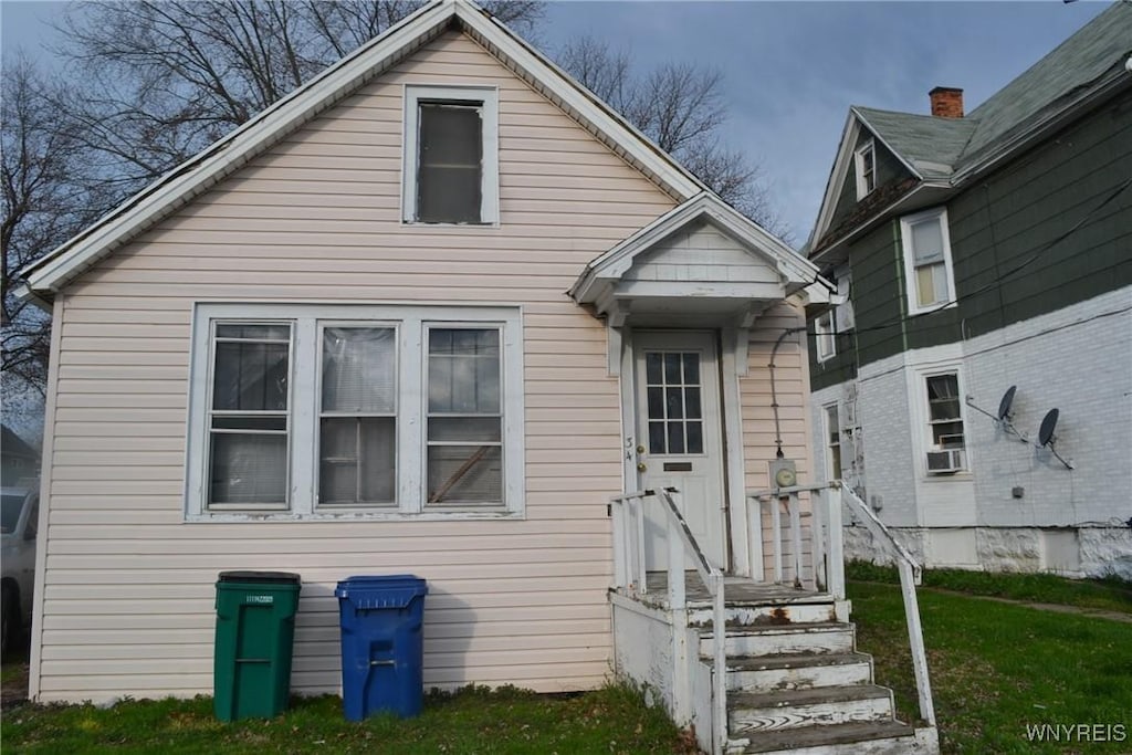 bungalow-style home with a front yard