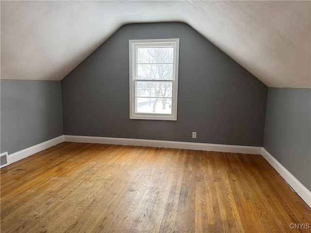 bonus room featuring lofted ceiling and light wood-type flooring