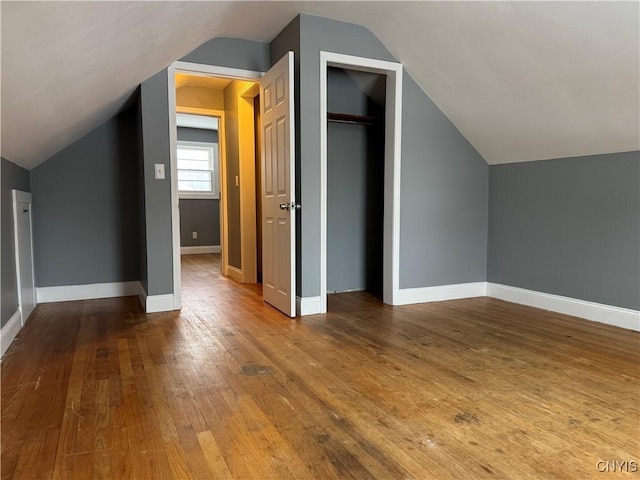 additional living space featuring hardwood / wood-style flooring and lofted ceiling