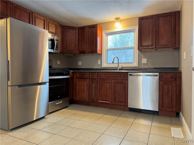 kitchen featuring stainless steel appliances, sink, and light tile patterned floors