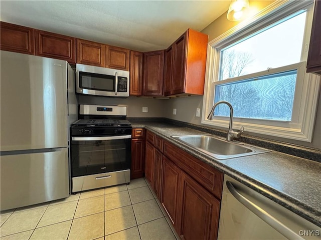 kitchen with sink, light tile patterned floors, and stainless steel appliances