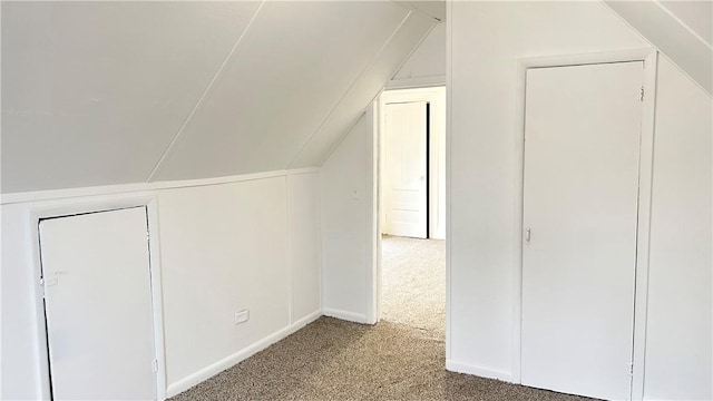 bonus room with carpet flooring and vaulted ceiling