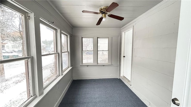 unfurnished sunroom featuring ceiling fan