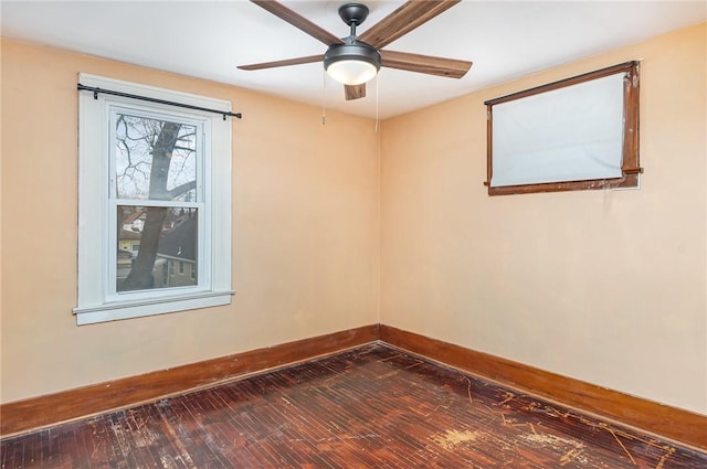 empty room with dark hardwood / wood-style flooring and ceiling fan