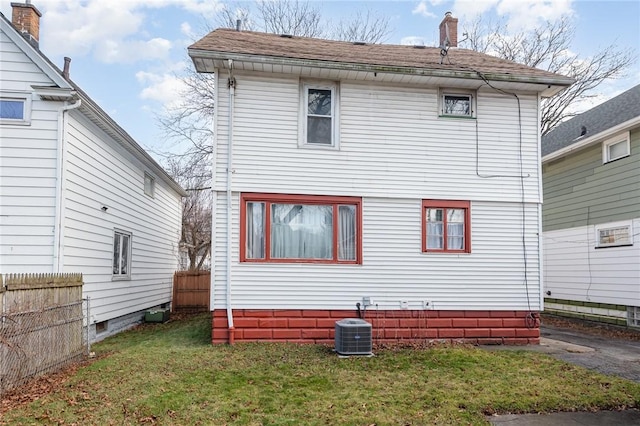 rear view of house featuring a yard and central AC