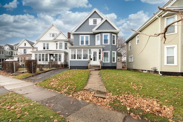 view of front of home featuring a sunroom and a front lawn