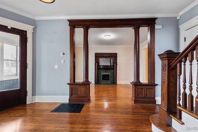 entryway featuring dark hardwood / wood-style flooring, ornamental molding, and decorative columns