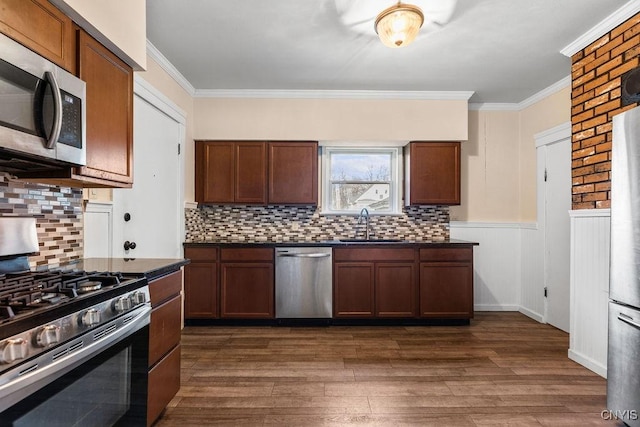 kitchen with dark hardwood / wood-style flooring, sink, stainless steel appliances, and ornamental molding