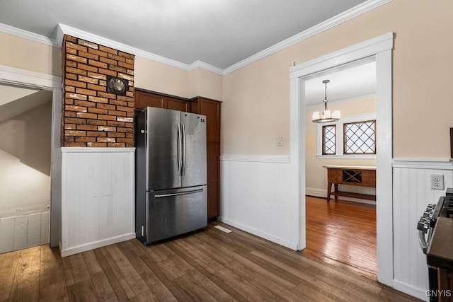 kitchen featuring stove, dark wood-type flooring, stainless steel refrigerator, and ornamental molding