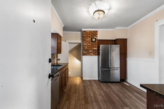 kitchen featuring dark hardwood / wood-style flooring, stainless steel appliances, and crown molding