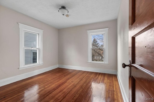 spare room with hardwood / wood-style flooring and a textured ceiling