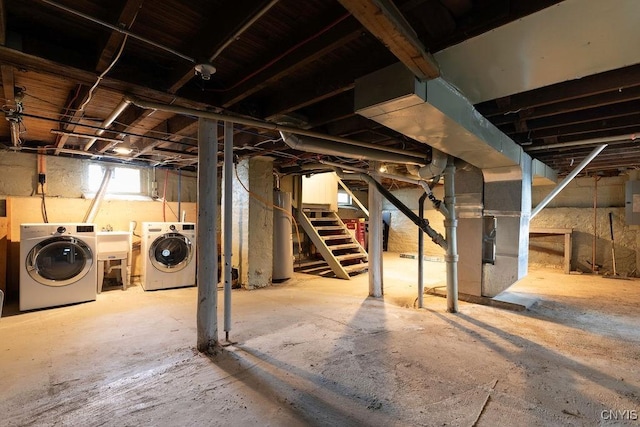 basement featuring electric panel, water heater, washer and clothes dryer, and sink