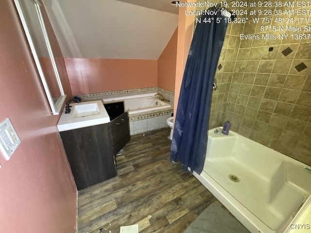 full bathroom featuring vanity, vaulted ceiling, wood-type flooring, plus walk in shower, and toilet