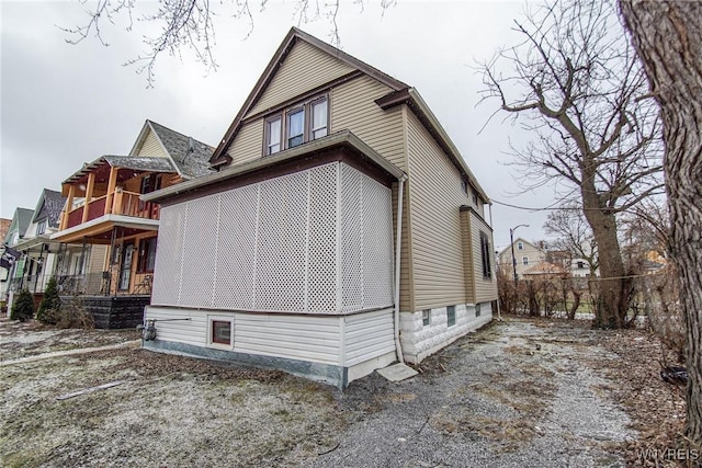 view of side of home with a porch and a balcony