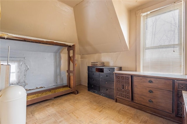 unfurnished bedroom featuring light parquet floors and vaulted ceiling