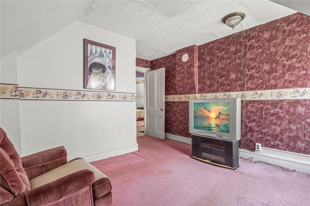 sitting room with a textured ceiling, carpet flooring, and lofted ceiling