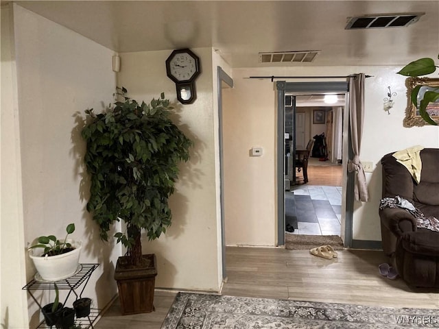 hall featuring a barn door and hardwood / wood-style flooring