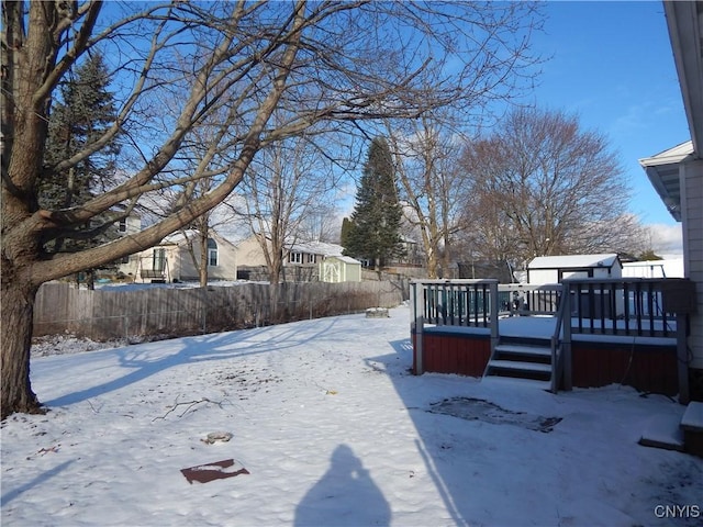 yard covered in snow featuring a deck