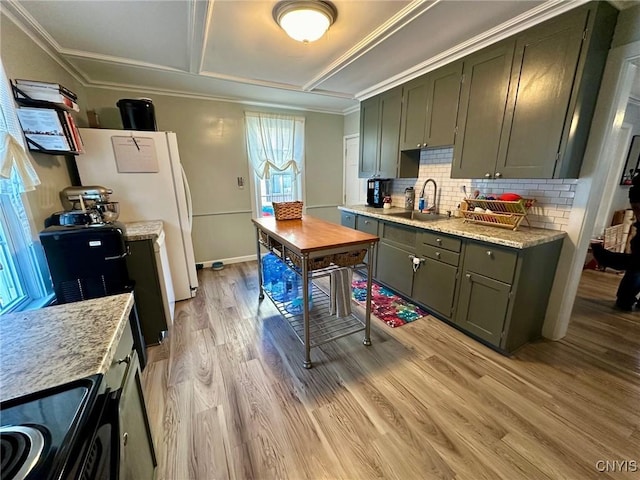 kitchen featuring light stone countertops, sink, stove, light hardwood / wood-style floors, and decorative backsplash