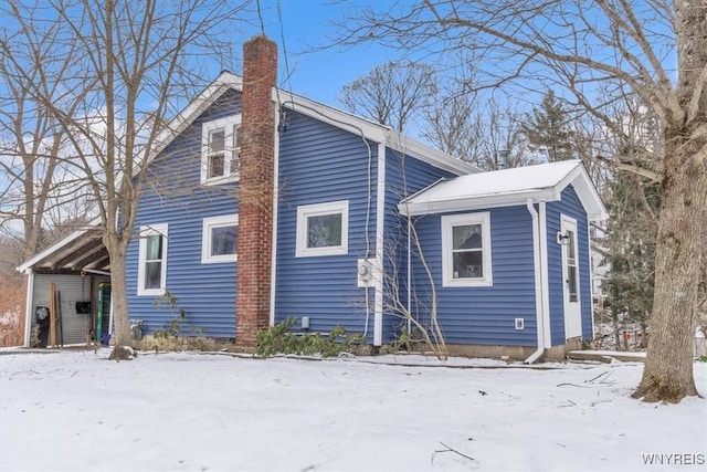 snow covered property featuring a carport