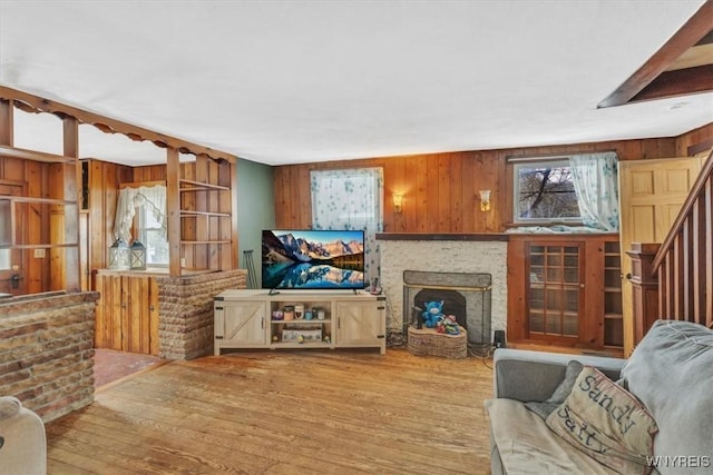 living room featuring wooden walls and light hardwood / wood-style flooring