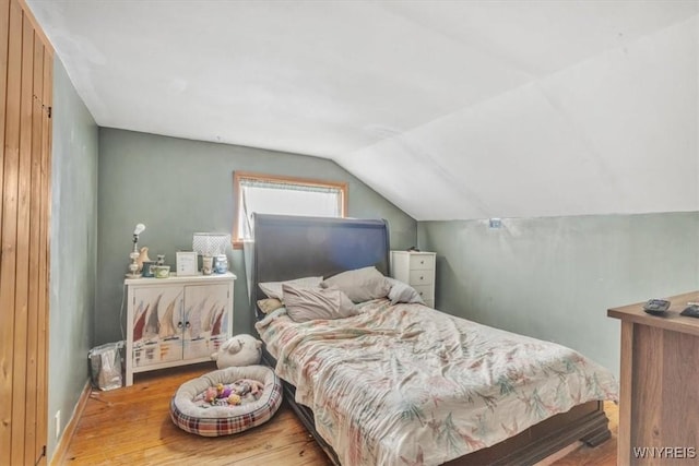 bedroom featuring hardwood / wood-style floors and vaulted ceiling