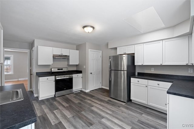 kitchen with white cabinets, appliances with stainless steel finishes, and dark wood-type flooring