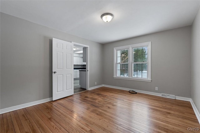 unfurnished bedroom with hardwood / wood-style flooring and a walk in closet