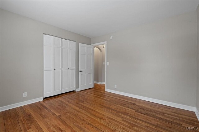 unfurnished bedroom with wood-type flooring and a closet